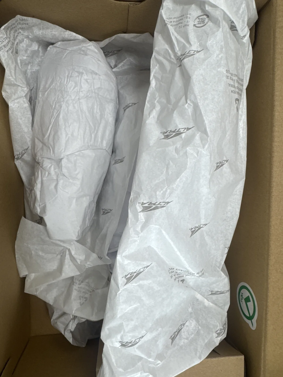 Caja abierta con las Altra Torin 9 envueltas en papel de la marca